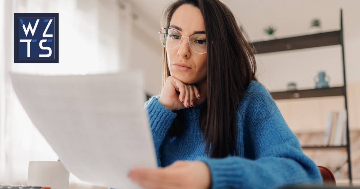 Focused woman reading financial documents at home